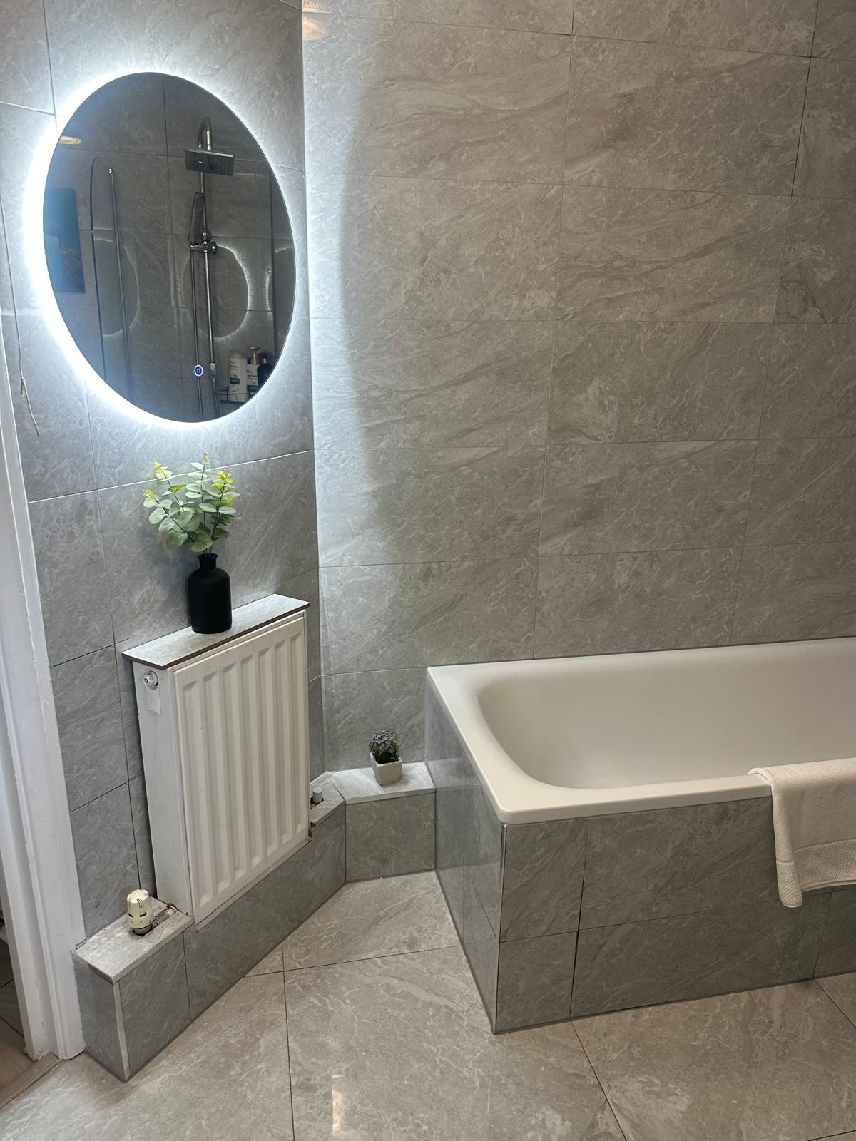 Luxury bathroom renovation with marble-effect tiling by MN Construction in Fulham, London