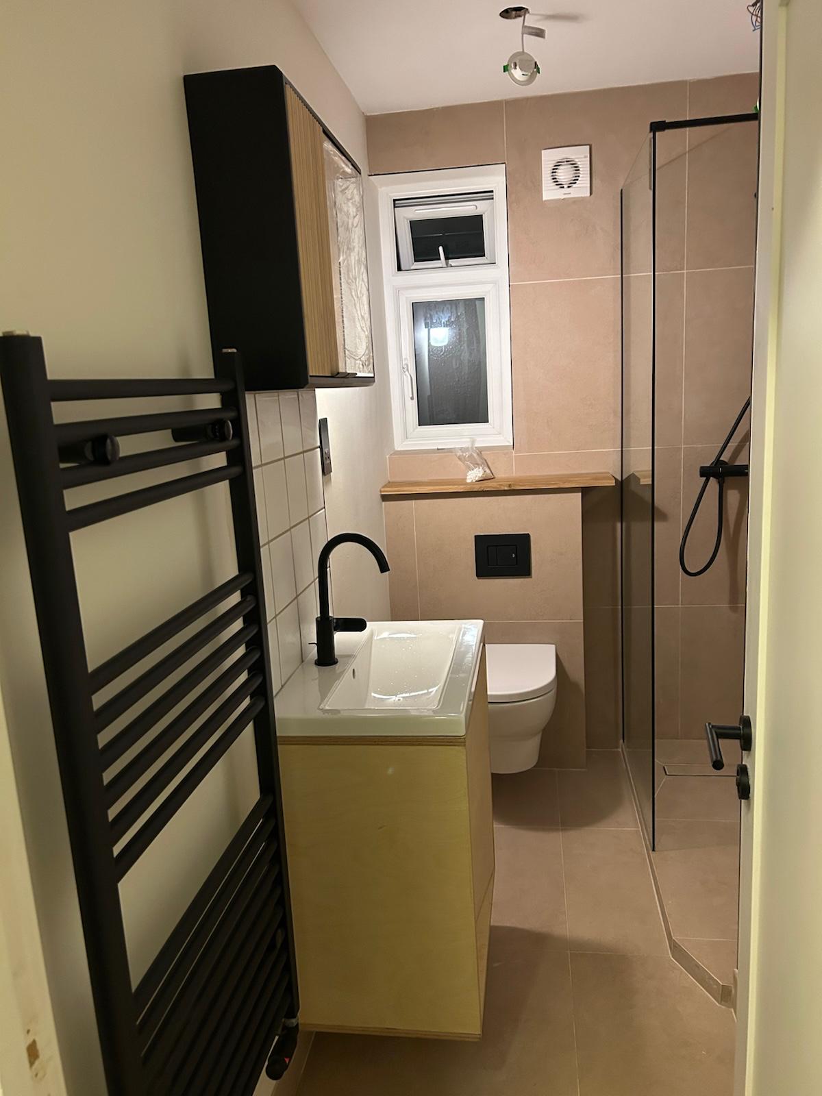 Contemporary bathroom installation with large-format wall tiles and LED mirror