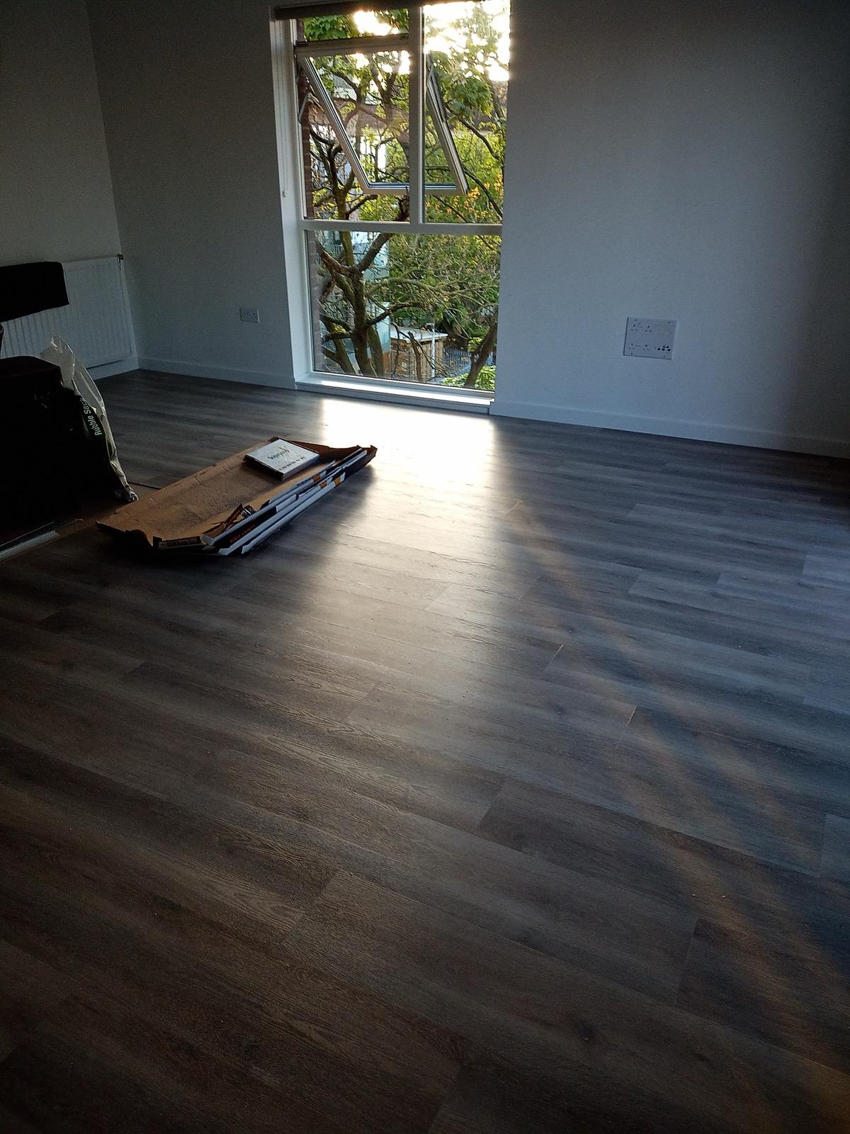 Dark stained hardwood flooring installation in modern living space
