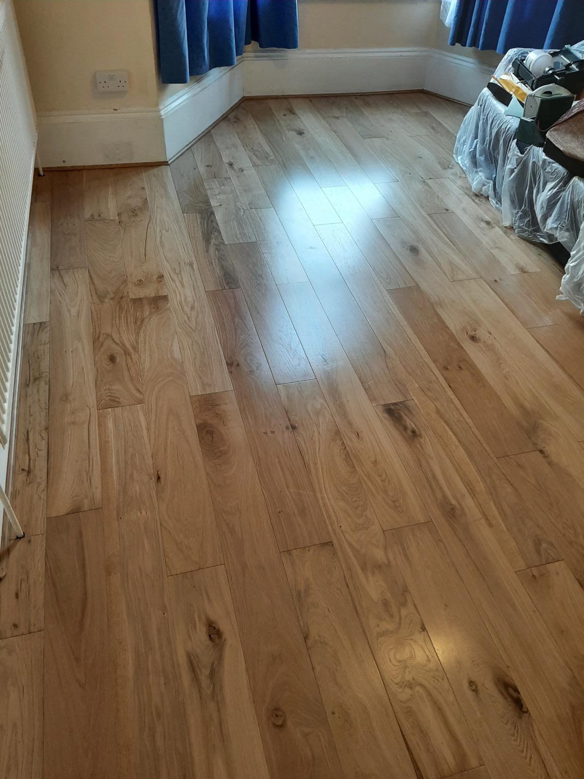 Solid oak plank flooring installation in bedroom