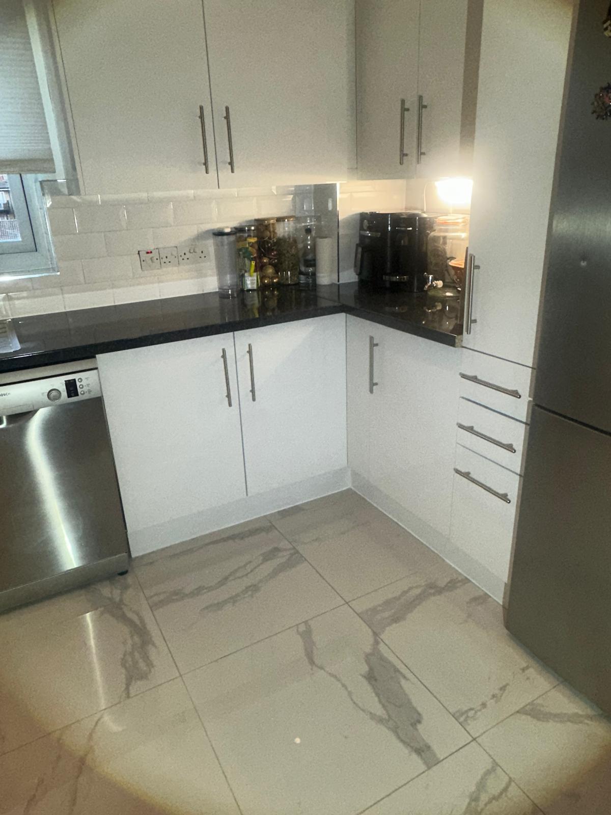White handleless kitchen with quartz worktops and pendant lighting