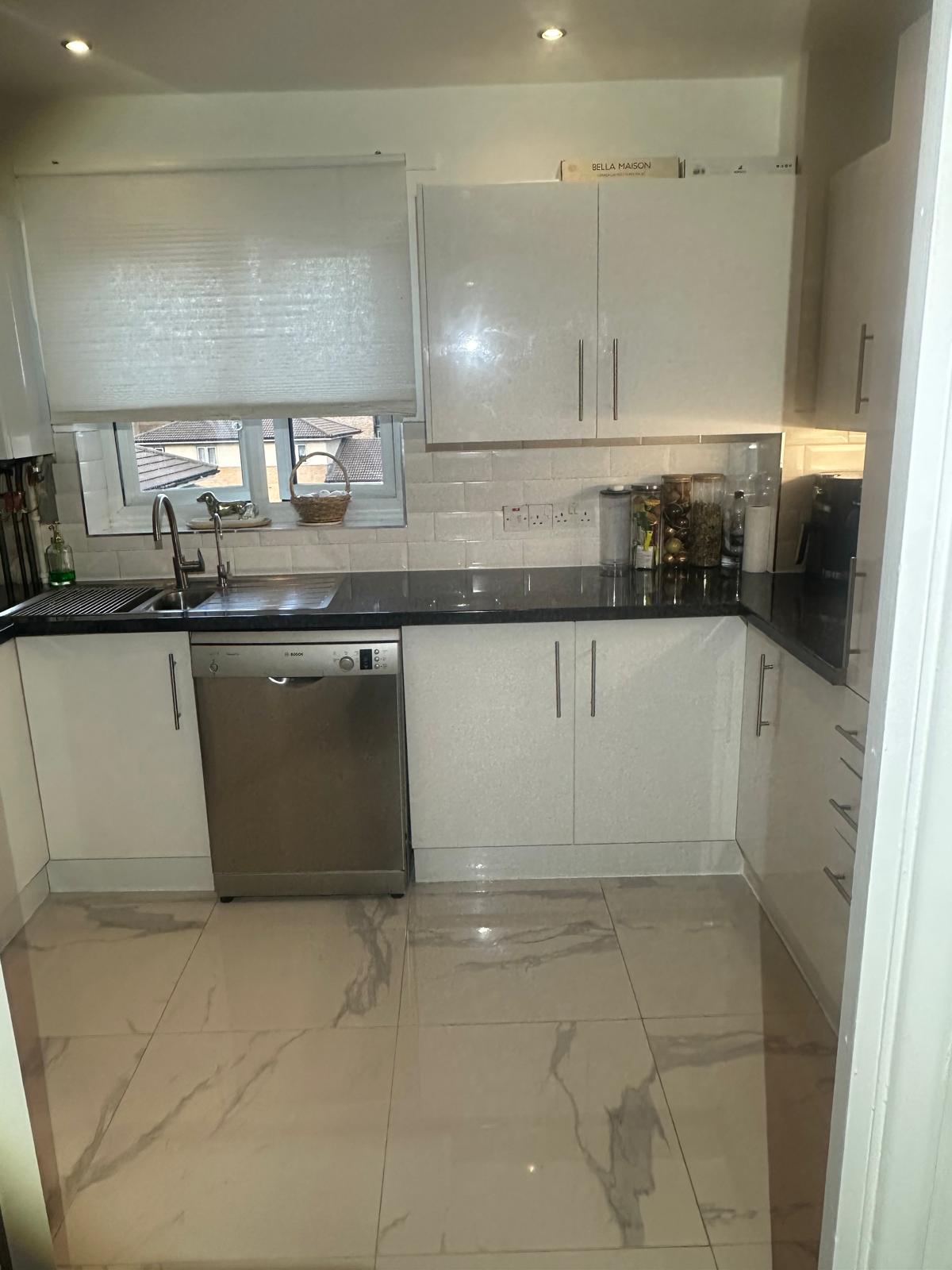 Open-plan white kitchen refurbishment with island unit
